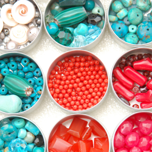 Containers hold beads of various shapes and sizes sorted by colour.